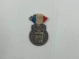 une médaille d'argent ornée d'un ruban rouge, blanc et bleu