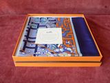 une boîte orange avec un foulard bleu et blanc et un foulard violet et bleu