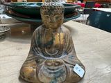 a buddha statue sitting on a table in a room