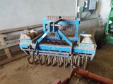 a blue machine that is sitting in the dirt