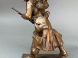 bronze figurine of a man with a rifle and a dog