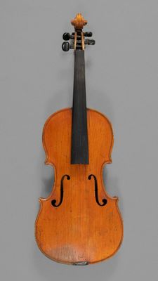 an old violin with a bow hanging on a wall