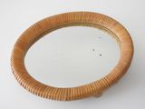 un miroir rond avec un cadre en bois posé sur une surface blanche
