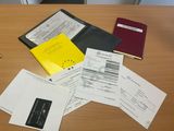 a lot of papers on a table with a cell phone