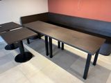 two tables and a bench in the corner of the room