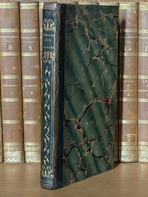 un livre posé sur une étagère, devant une pile de livres