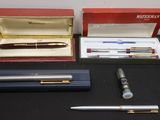 three pens and a pen in a box on a table