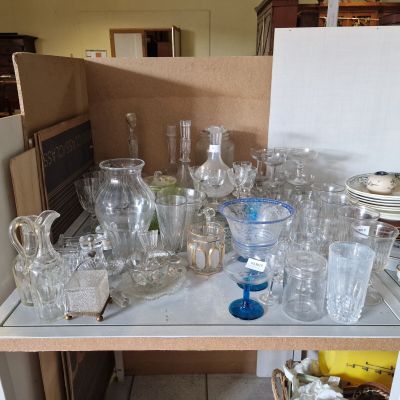 des bouteilles et des verres posés sur une table dans une cuisine où se trouve un réfrigérateur