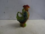a small figurine of a rooster sitting on a table