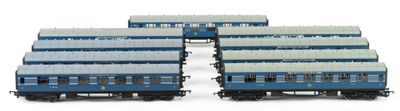 four blue and white train cars sitting next to each other on a white surface