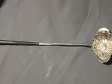 a silver spoon with a flower on it sitting on a table
