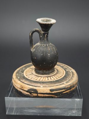 un vase noir posé sur un socle en bois