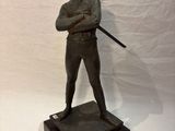 statue of a man holding a baseball bat on a wooden base