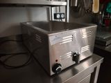 un plan de travail en acier inoxydable sur lequel est posé un grille-pain, dans une cuisine