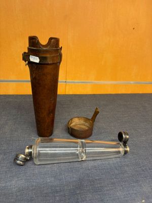 une bouteille en verre et une paire de ciseaux par terre