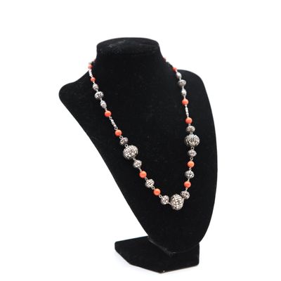a necklace with coral and silver beads on a black mannequin