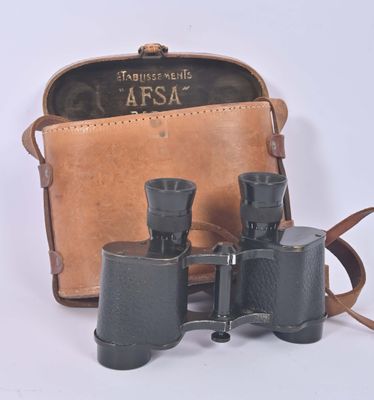 an old pair of binoculars sitting on top of a brown bag