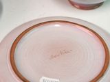 a pink plate with a name on it sitting on a table