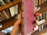 une personne tenant un livre à la main devant une bibliothèque remplie de livres
