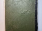 a green book sitting on top of a table next to a white wall