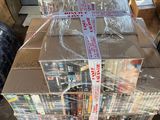 a large stack of books wrapped in plastic on top of a carton
