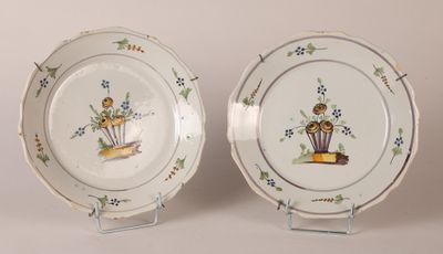 two plates with flowers on them are sitting on a stand