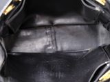 the inside of a black purse with gold hardware on the handles