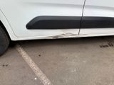 a white van with a black stripe parked in a parking lot