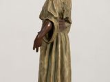 statue of a woman in a green dress standing on a wooden table