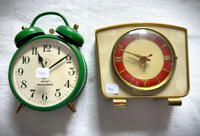 deux horloges placées l'une à côté de l'autre sur une surface blanche