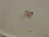 a white plate with a red stamp on it on a table