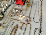 many different types of necklaces and bracelets laid out on a table