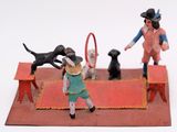 toy figurines of a boy playing with a dog and a tennis racket