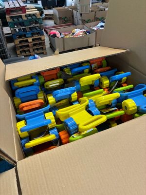 une boîte en carton remplie d'une multitude de pistolets jouets de toutes les couleurs
