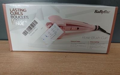 packaging of a babylis rose brush curler on a wooden table
