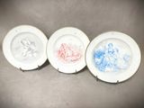 trois assiettes à motifs différents posées sur une table