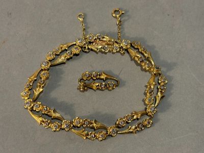 a gold necklace and bracelet set on a table