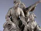 statue of a woman and a man sitting on a rock with a guitar