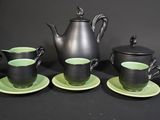 four cups and a teapot sitting on a table