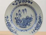 a blue and white plate with flowers and birds on it