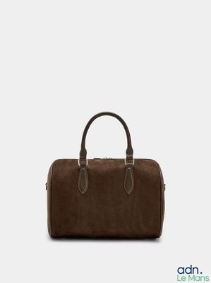 a brown handbag sitting on top of a white surface