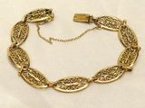 an image of a gold bracelet on a white cloth