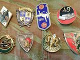 a lot of badges that are laying on a camouflage surface