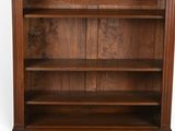 an old wooden bookcase with three shelves and a door