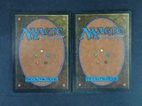 two magic the gathering cards are shown on a black surface