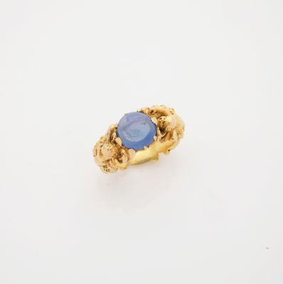 une bague en or avec une pierre bleue au centre