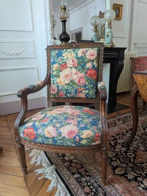 a chair with a floral upholstered seat in a living room