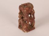 a figurine of a man and a woman sitting on a rock