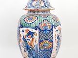 a blue and white vase with a bird on top of it
