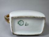a white porcelain box with a gold band around it